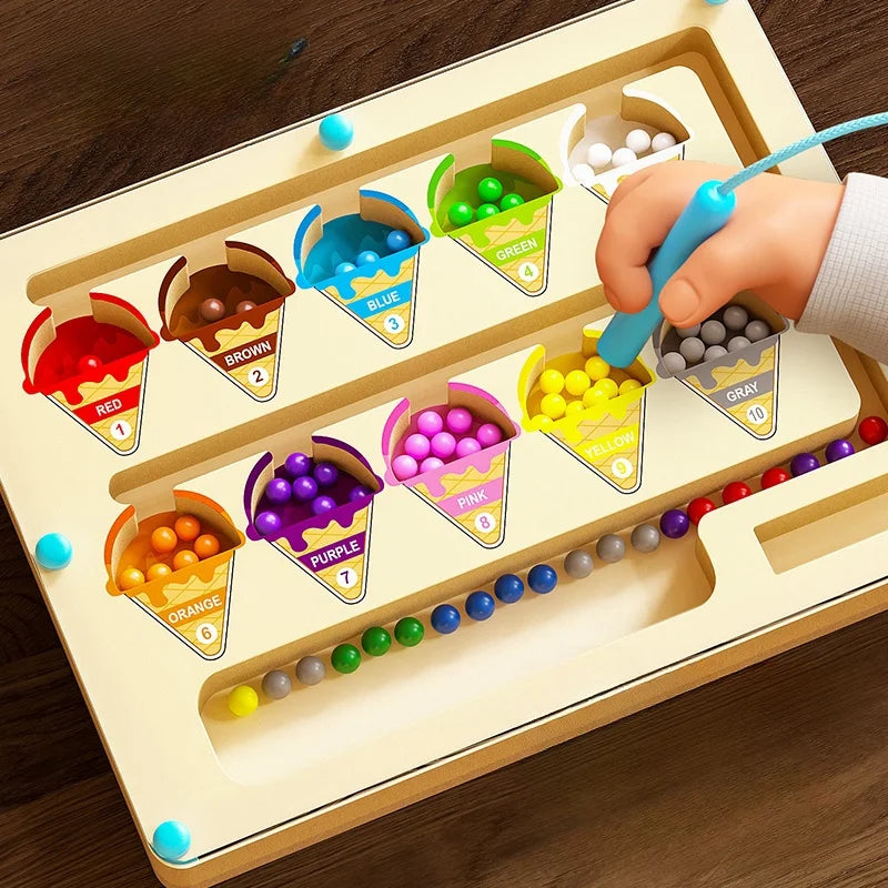 Color sorting toy with labeled bins and colorful beads on a wooden surface