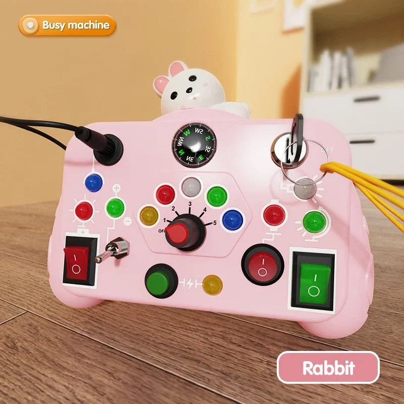 Pink toy control panel with rabbit figure on a wooden surface